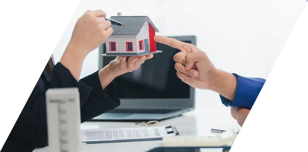 書類とパソコンが置かれたデスクで住宅プランについて話し合うシーン